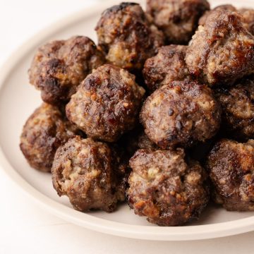 A pile of oven-baked meatballs on a plate.