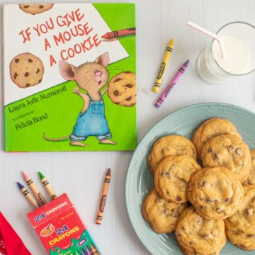 The cover of the book "If You Give a Mouse a Cookie" next to a plate of small-batch chocolate chip cookies, a glass of milk, and some crayons.