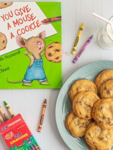 The cover of the book "If You Give a Mouse a Cookie" next to a plate of small-batch chocolate chip cookies, a glass of milk, and some crayons.