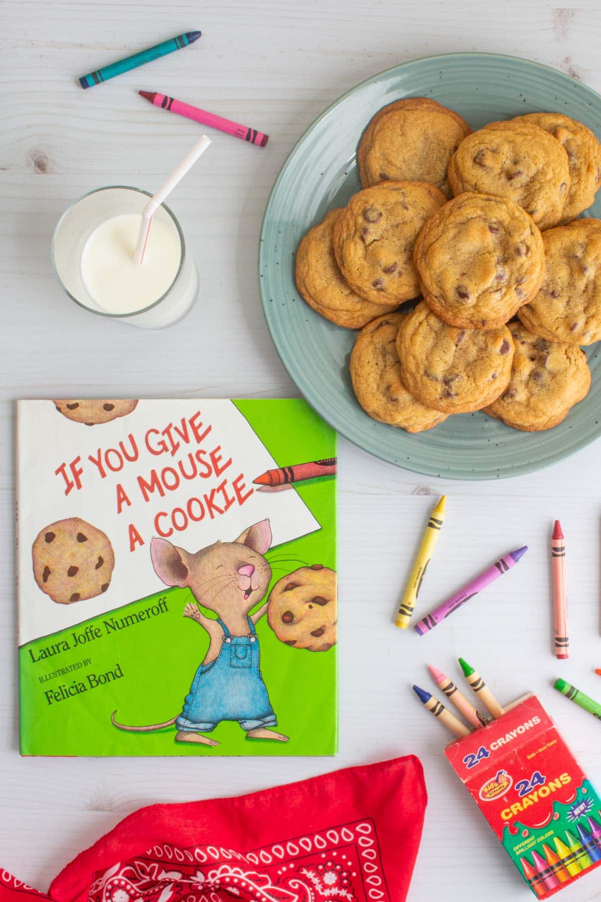 The cover of the book "If You Give a Mouse a Cookie" next to a plate of small-batch chocolate chip cookies, a glass of milk, a red bandana, and some crayons.