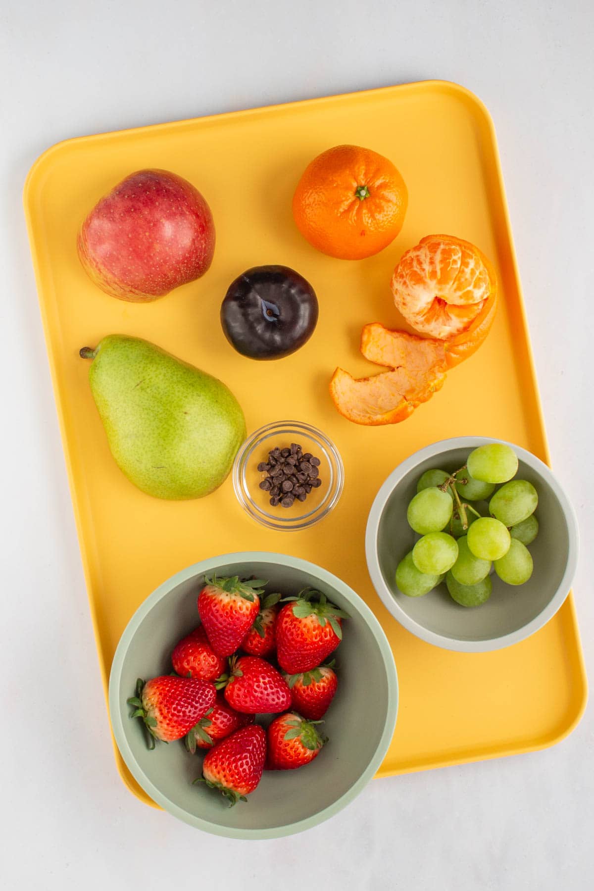 The ingredients for fruit skewers on a tray.