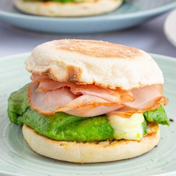 Cooked and assembled green eggs and ham breakfast sandwiches.