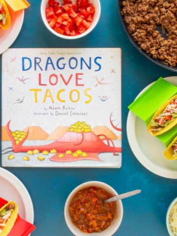 The cover of the book "Dragons Love Tacos" surrounded by a skillet of ground beef, toppings, and assembled Ground Beef Tacos.