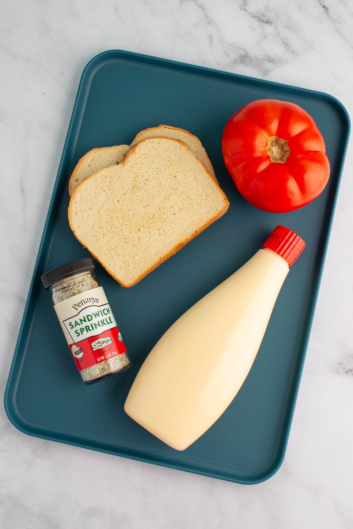 Ingredients for an ultimate umami tomato sandwich on a tray.