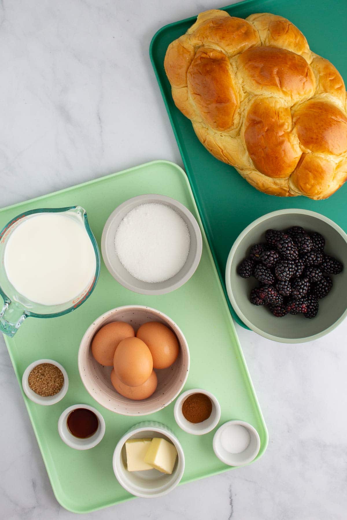 Ingredients for Blackberry Bread Pudding measured out on trays.