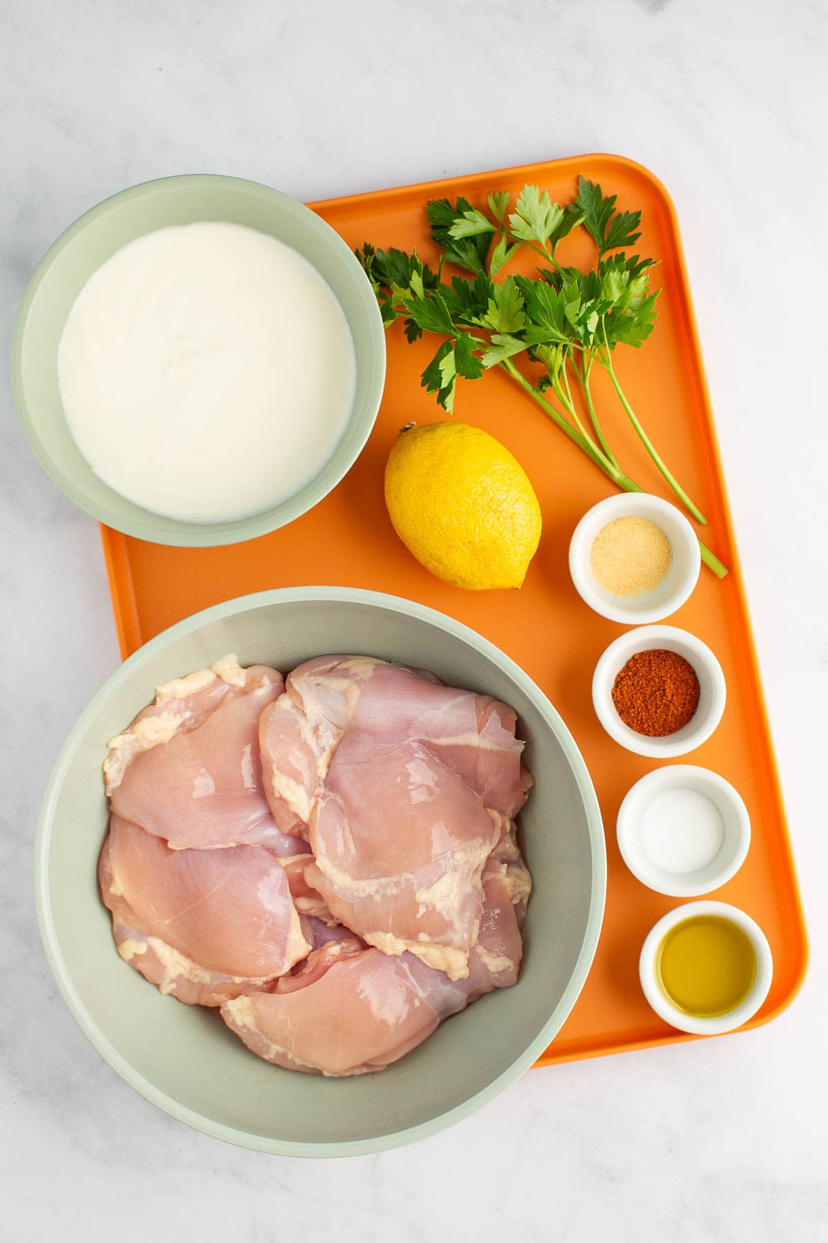 Ingredients for Juicy Yogurt Baked Chicken measured out on a tray.