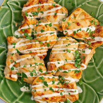 A platter of Juicy Yogurt-Baked Chicken sprinkled with parsley.