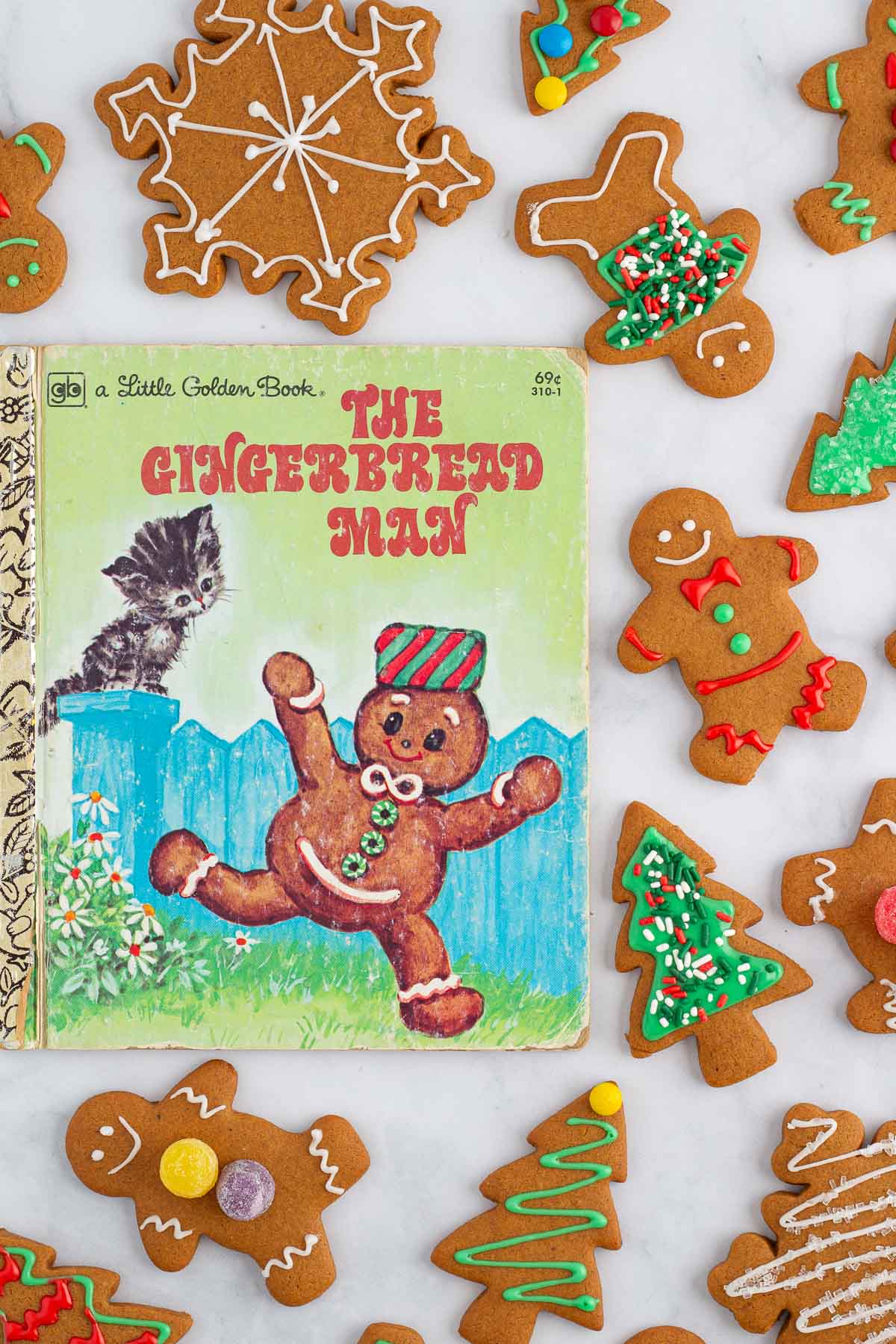 The cover of the book The Gingerbread Man, surrounded by baked and decorated gingerbread cookies.