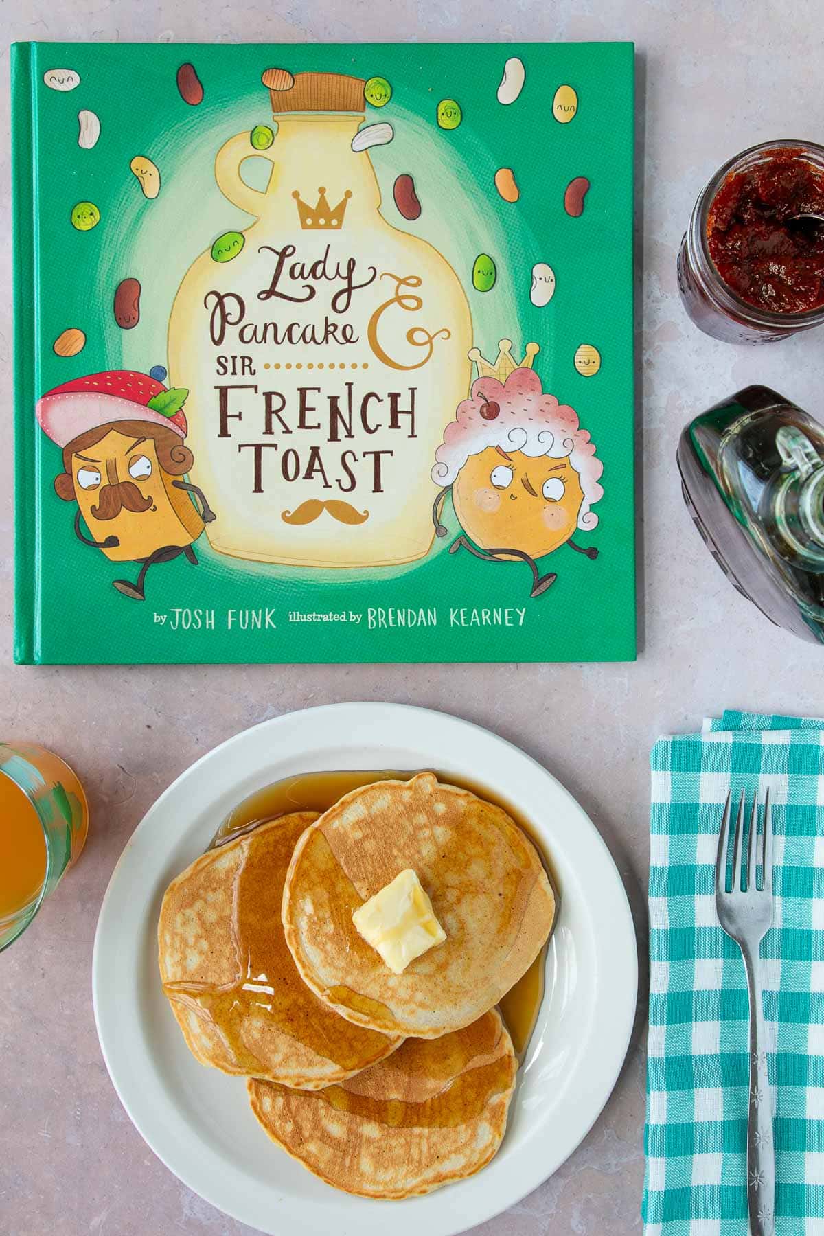 A plate of pancakes with syrup next to the cover of the book Lady Pancake & Sir French Toast.