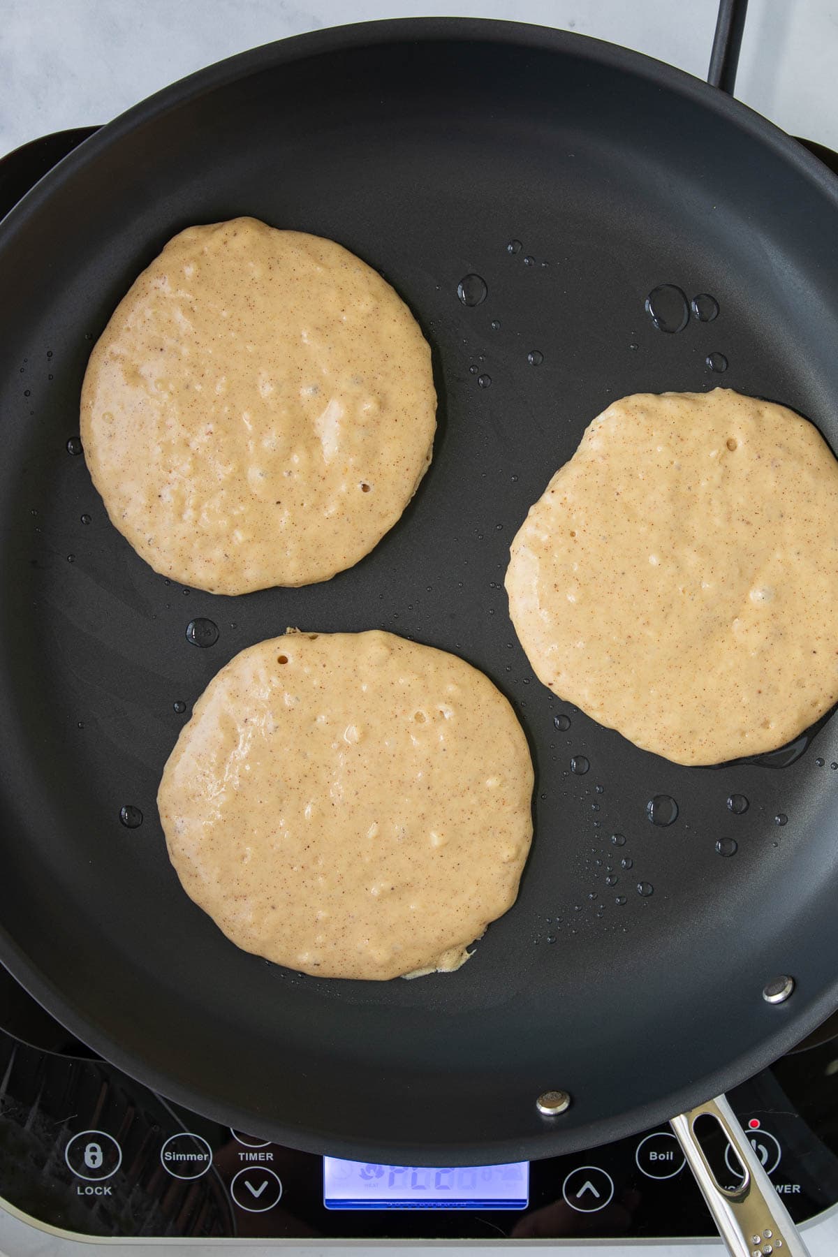 One-Bowl French Toast Pancakes cooking in a skillet.