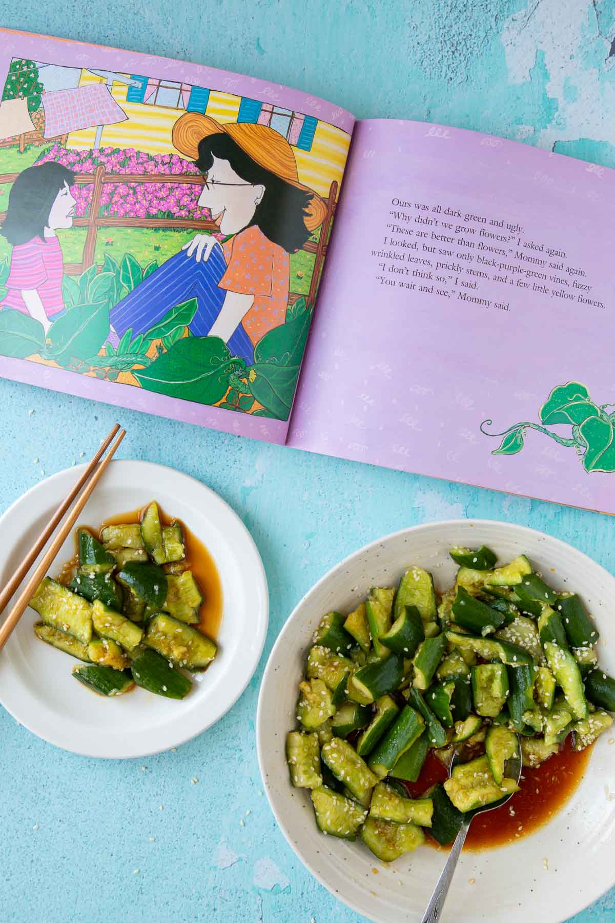 The book The Ugly Vegetables open to a page, with a bowl and plate of smashed cucumber salad nearby.