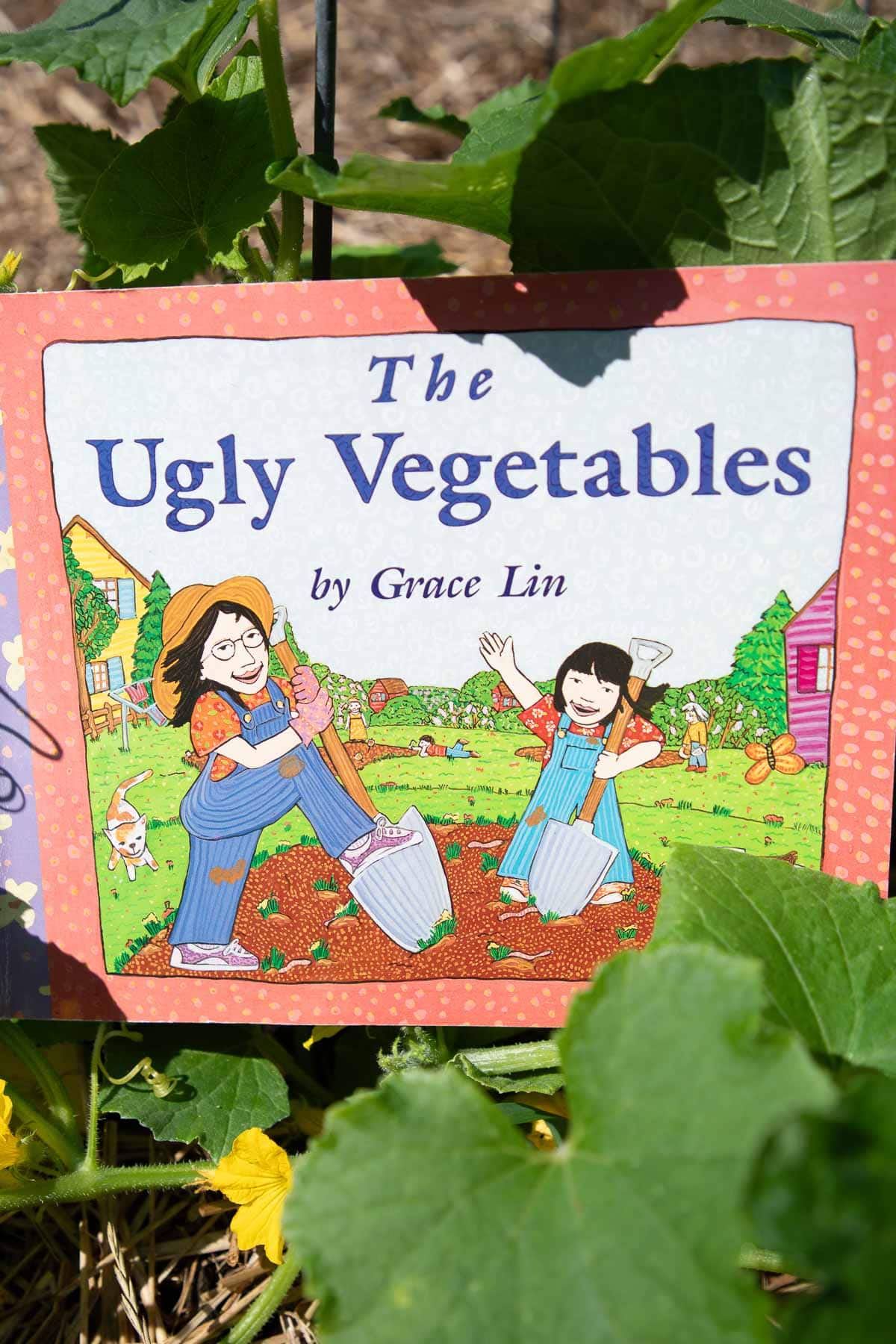 The cover of the book The Ugly Vegetables surrounded by vines in a garden.