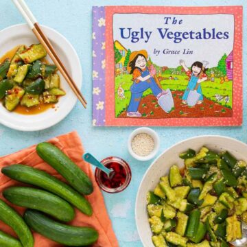 The cover of the book The Ugly Vegetables, with a bowl and plate of smashed cucumber salad, a jar of chili crisp, and a pile of cucumbers nearby.