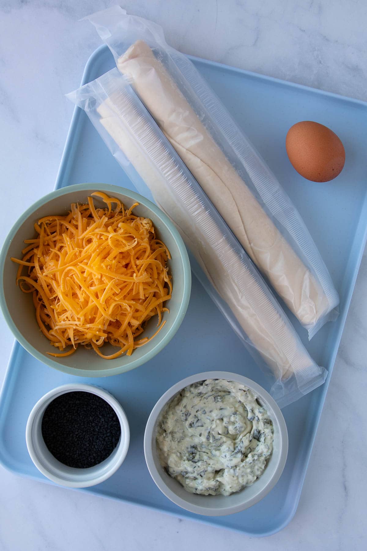 Ingredients for Cheddar-Artichoke Bat Tarts measured out on a tray.
